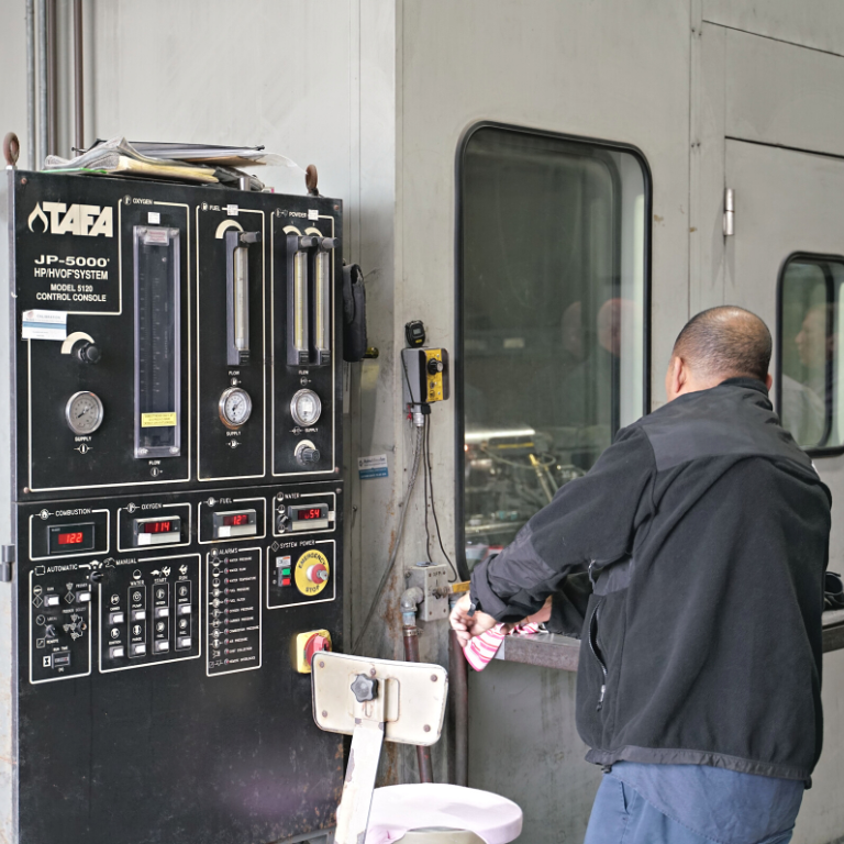 Operator running the HVOF thermal spray system at H&M Plating